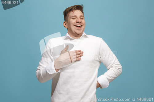Image of The happy businessman standing and smiling against blue background.