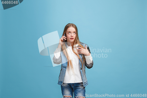 Image of Beautiful teen girl looking suprised isolated on blue