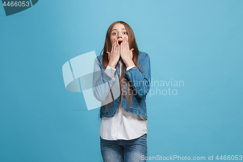 Image of Beautiful teen girl looking suprised isolated on blue