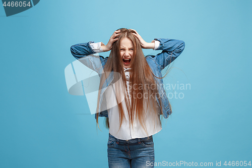 Image of The squint eyed teen girl with weird expression isolated on blue