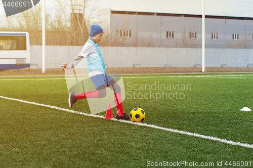 Image of Boy kicking soccer ball