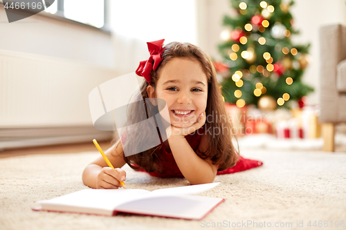 Image of little girl writing christmas wish list at home