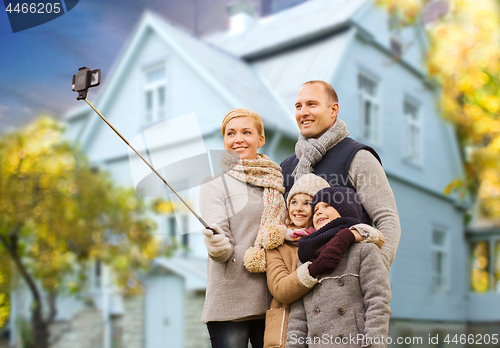 Image of family takes autumn selfie by cellphone over house