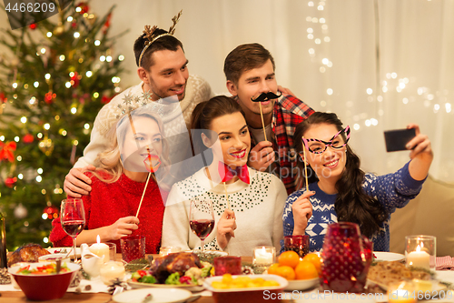 Image of friends taking selfie at christmas dinner