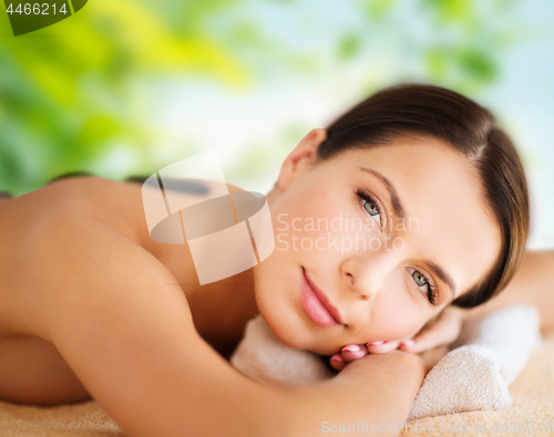 Image of beautiful woman having hot stone therapy at spa