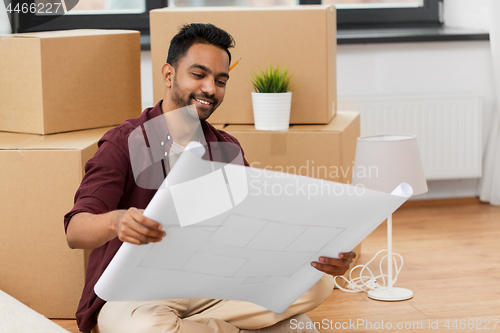 Image of man with blueprint and boxes moving to new home