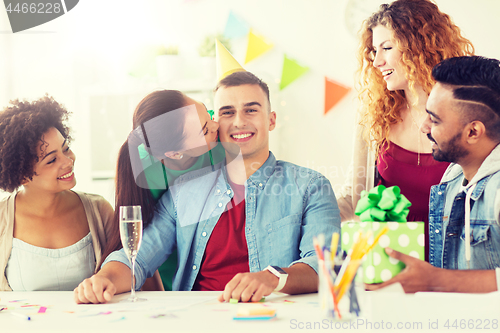 Image of team greeting colleague at office birthday party