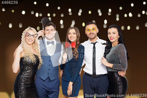 Image of happy friends with party props posing