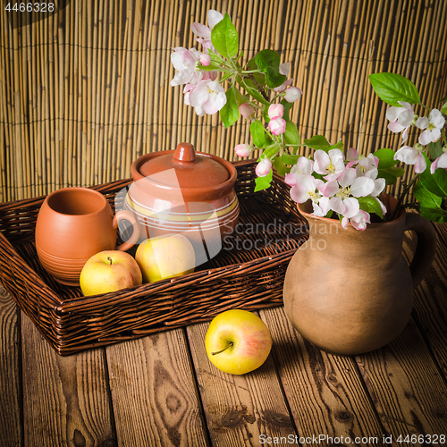 Image of Ripe apple and blossoming branch of an apple-tree in a clay jar,