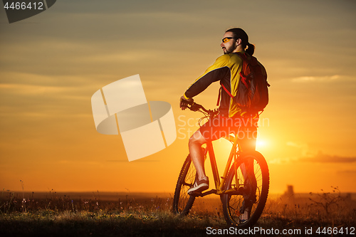 Image of Man in helmet and glasses stay on the bicycle