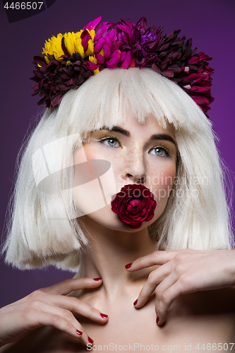 Image of Beautiful girl with rose in mouth