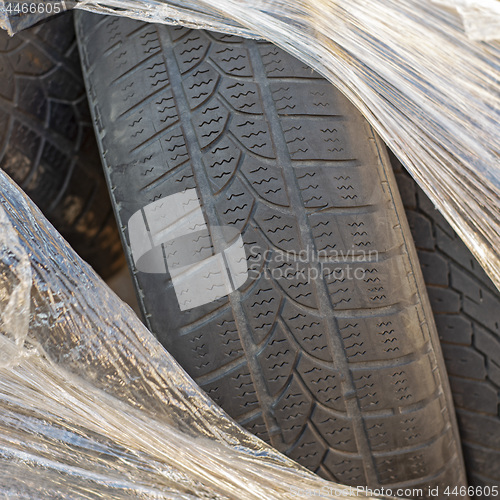 Image of Worn out tires of heavy vehicles wrapped in plastic.