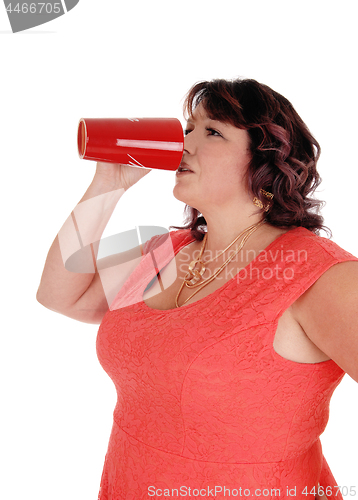 Image of Plus-sized woman drinking from red mug