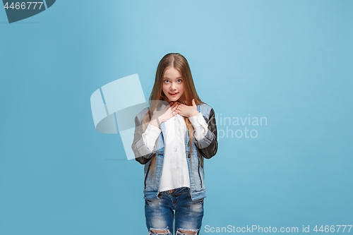 Image of The happy teen girl standing and smiling against pink background.