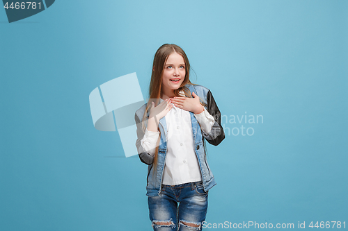 Image of The happy teen girl standing and smiling against pink background.