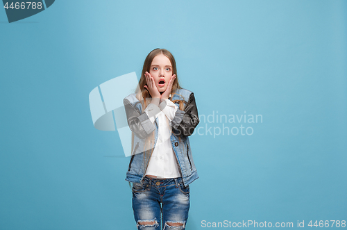 Image of Beautiful teen girl looking suprised isolated on blue