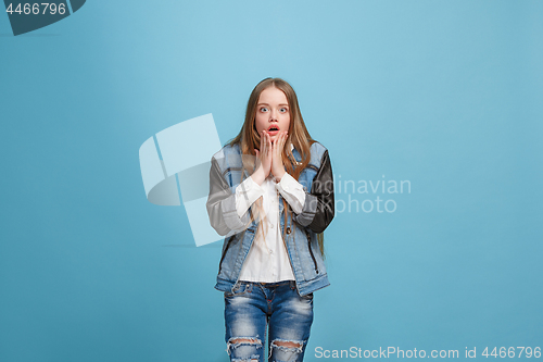 Image of Beautiful teen girl looking suprised isolated on blue