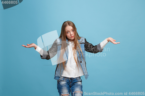 Image of Beautiful teen girl looking suprised and bewildered isolated on blue