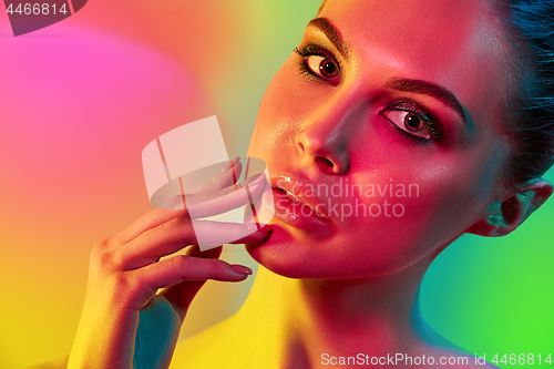 Image of High Fashion model woman in colorful bright lights posing in studio