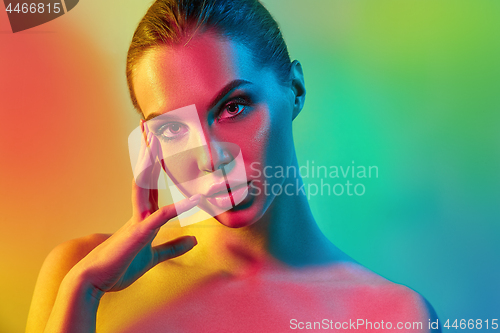 Image of High Fashion model woman in colorful bright lights posing in studio