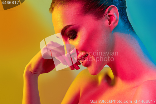 Image of High Fashion model woman in colorful bright lights posing in studio