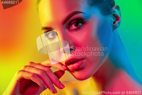 Image of High Fashion model woman in colorful bright lights posing in studio