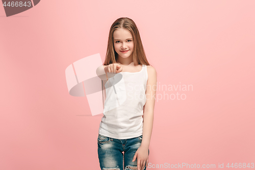 Image of The happy teen girl pointing to you, half length closeup portrait on pink background.