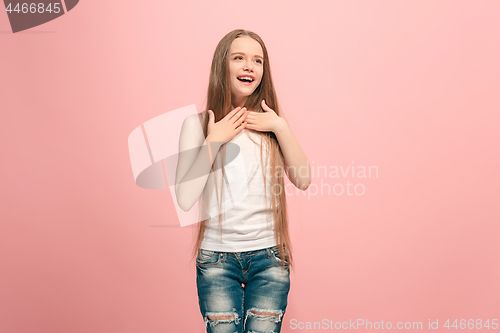 Image of The happy teen girl standing and smiling against pink background.