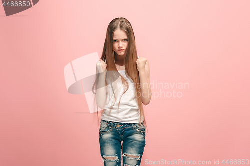 Image of Portrait of angry teen girl on a pink studio background