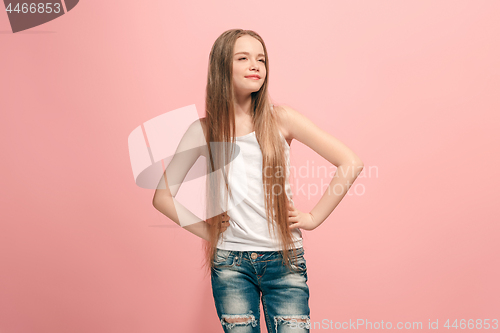 Image of The happy teen girl standing and smiling against pink background.