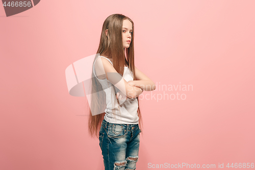 Image of Portrait of angry teen girl on a pink studio background