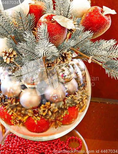 Image of Christmas holidays composition with red apples, silver balls, andglass vase