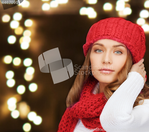 Image of woman in hat and scarf over lights background