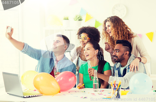 Image of happy team taking selfie at office party