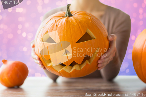 Image of close up of woman with halloween pumpkin