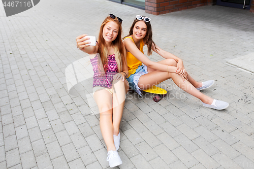 Image of teenage girls taking selfie on city street