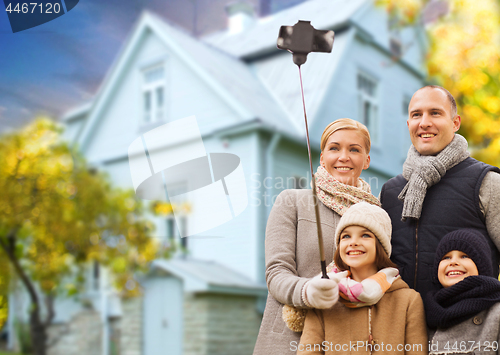 Image of family takes autumn selfie by cellphone over house