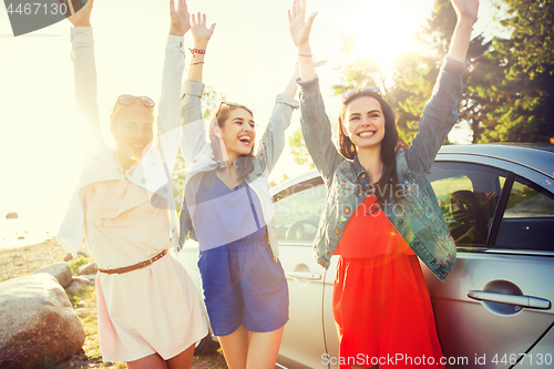 Image of happy teenage girls or women near car at seaside