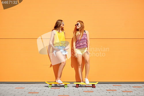 Image of teenage girls with short skateboards in city