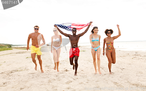 Image of happy friends with american flag on summer beach