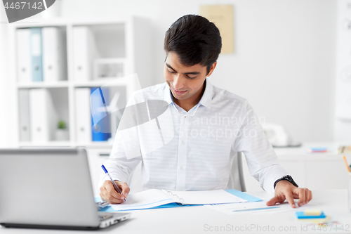 Image of businessman working with papers at office