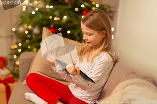 Image of smiling girl with tablet pc at christmas home