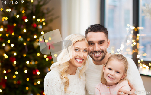 Image of happy family at home over christmas tree lights