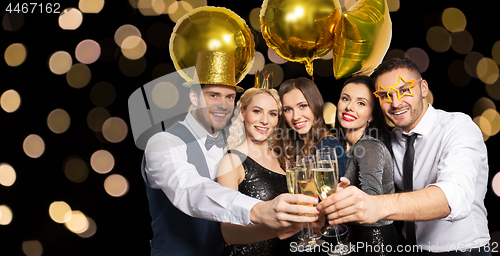 Image of happy friends clinking champagne glasses at party