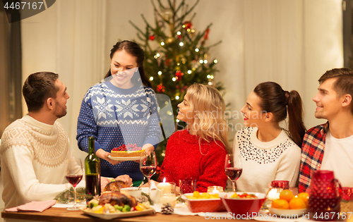 Image of happy friends having christmas dinner at home