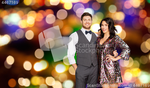 Image of happy couple hugging at party over festive lights