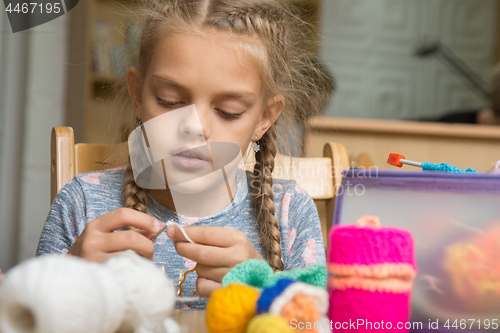 Image of Portrait of a girl enthusiastically engaged in knitting