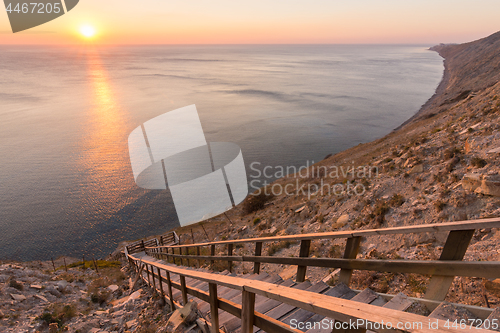 Image of Ladder going down to the sea on a rocky cliff, sunset, Anapa, Russia