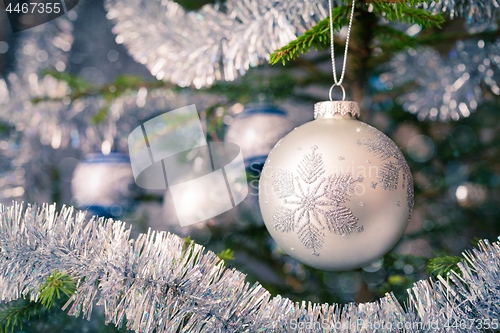 Image of Christmas-tree decoration bauble on decorated Christmas tree bac