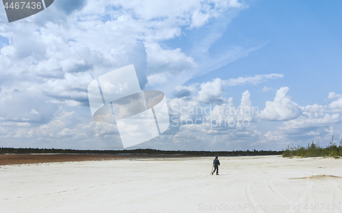 Image of Person Walking Through Sandy Desert Under a Beautiful Sky